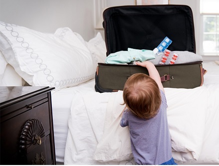 A child tries to get into a suitcase full of medication